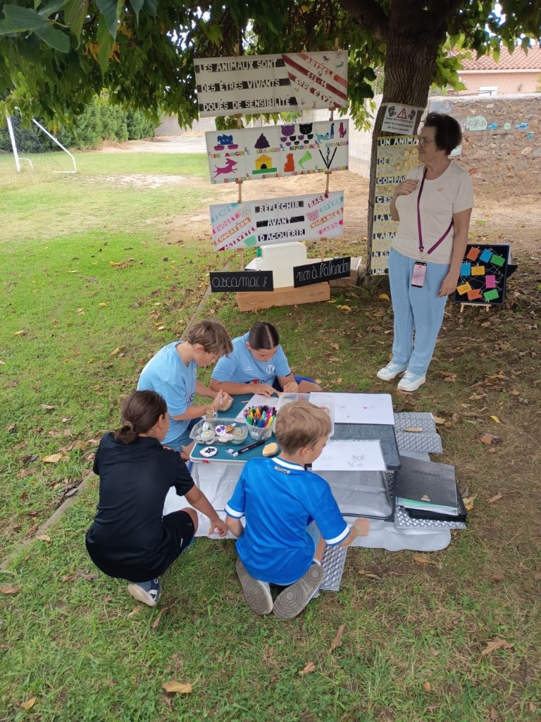Des enfants, vus de dos, participent à l’atelier créatif d’ASCaMaC à Baixas ; aucun visage identifiable n’est visible.